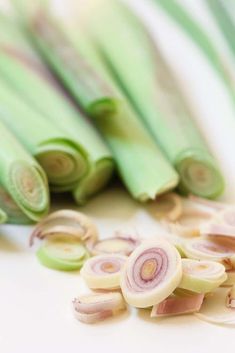 green onions and onion slices on a white surface