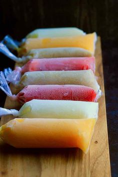 four popsicles are lined up on a cutting board