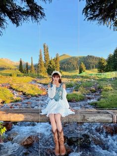 a woman sitting on top of a log over a river next to a lush green forest