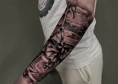 a man's arm with a compass tattoo on it