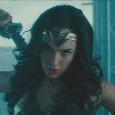 wonder woman standing in front of a window with her hands on her hips and looking at the camera