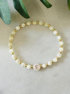 - Beautiful dainty pearl initial bracelet that makes a gorgeous bracelet gift. Soft and delicate with tiny 18 gold filled beads and freshwater shell initial bead. Coordinating pieces in shop. Beaded on high quality stretch cord and secured. - 3mm 18k gold filled beads   4mm mother of pearl beads    8mm freshwater shell initial bead. - Purchase is sent in a white velvet drawstring jewelry bag, making the perfect bracelet gift for bridesmaid, bracelet for mom, anyone special or just yourself. - To care for your bracelet, please roll on and off wrist. Repeated stretching can wear the elastic over time. Avoid excessive contact with water and chemicals. - We highly recommend measuring your wrist before ordering. Please see our sizing guide in the listing photos.  - We strive to get orders out a Pearl Bracelet With Letter Beads As Gift, Elegant Pearl Bracelet With Letter Beads, Casual Pearl Bracelet With Letter Beads For Gift, Personalized Adjustable Pearl White Bracelets, Initial Pearl Bracelet, Bridesmaid Bracelet Gift, Gold Pearl Bracelet, Bracelet Initial, Making Bracelets With Beads