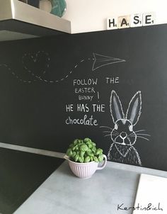 a bowl of green candy sitting on top of a counter next to a chalkboard