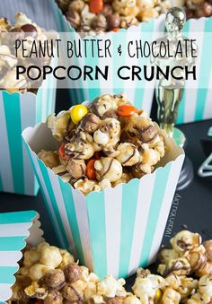 two blue striped popcorn cups filled with peanut butter and chocolate popcorn crunch, on top of a black table