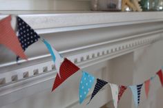 a red, white and blue bunting banner hanging from a mantel above a fireplace