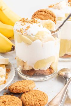 three desserts with banana slices, cookies and whipped cream in them on a table