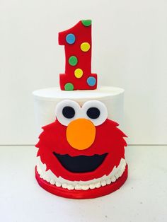 a birthday cake with the number one on it's top and an elmo face