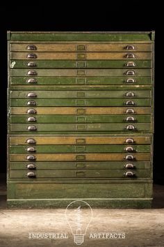 an old green metal filing cabinet with lots of drawers and knobs on the front