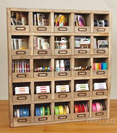 a wooden shelf filled with lots of different types of ribbons and tape dispensers