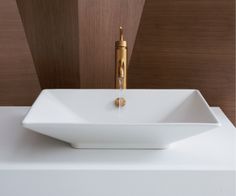 a bathroom sink with a gold faucet on the side and a white counter top