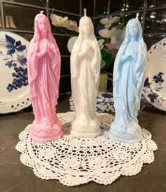 three small figurines sitting on top of a doily