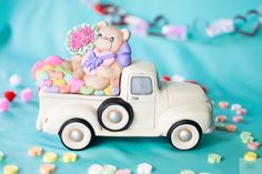 a teddy bear sitting in the back of a truck filled with candy