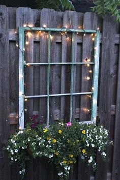 an old window is decorated with flowers and fairy lights