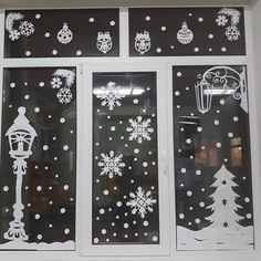 the window is decorated with white snowflakes and christmas decorations on black glass,