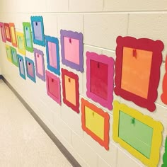 a wall with many different colored frames hanging from it's sides and on the side