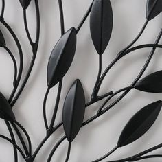 a metal sculpture with black leaves on it