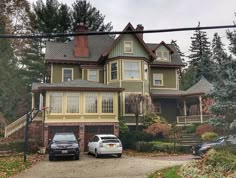 two cars parked in front of a large house