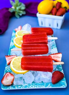 popsicles with strawberries and lemons on a plate