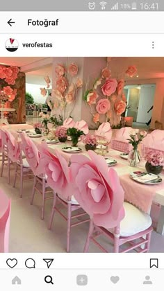 the table is set with pink flowers and place settings for guests to sit down at