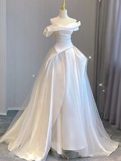 Taking inspiration from old Hollywood glamour, this beautiful A-line wedding dress is a true showstopper. The off-the-shoulder neckline and delicate pleats add a touch of elegance and sophistication to the dress, while the soft tulle fabric creates a dreamy and ethereal feel. White Cotillion Dresses, Winter Wedding Venues, Off The Shoulder Wedding Dress, Tulle Wedding Dresses, Shoulder Wedding Dress, Tulle Sleeves, Satin Tulle, White Wedding Dress, Satin Wedding Dress