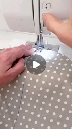 someone using a sewing machine to sew polka dot fabric