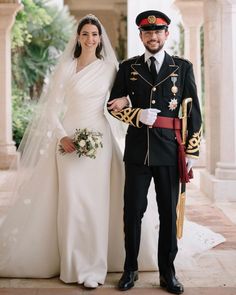 a man and woman in wedding attire standing next to each other