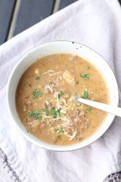 a white bowl filled with soup and topped with parsley