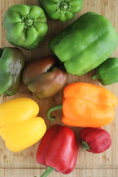 several different colored peppers on a cutting board