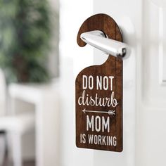 a wooden sign that says do not disturb the mom is working on it's door