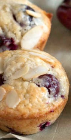 two blueberry muffins sitting on top of a piece of wax paper