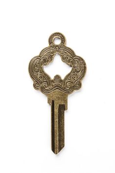 an antique key with ornate design on it's side, against a white background