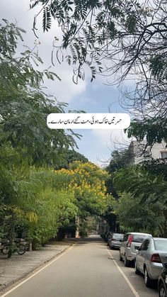 cars parked on the side of a road in front of trees and bushes with an advertisement written in english