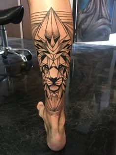 a man's leg with a tattoo on it and a lion head in the middle