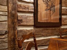 a wooden bench sitting in front of a log wall