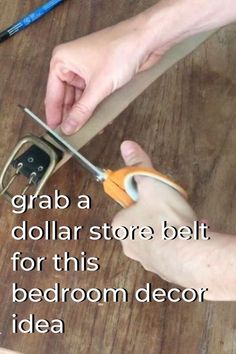 a person cutting paper with scissors on top of a wooden table