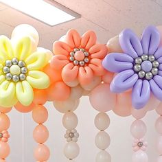 some balloons are hanging from the ceiling with flowers on them