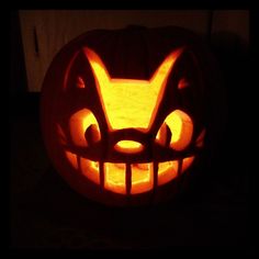 a pumpkin carved to look like an angry cat