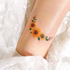 a woman's foot with sunflowers on it