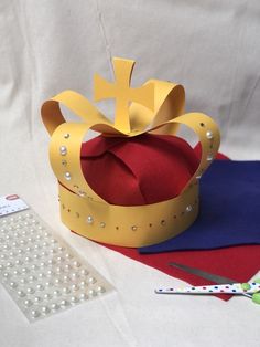 a paper crown sitting on top of a table next to scissors