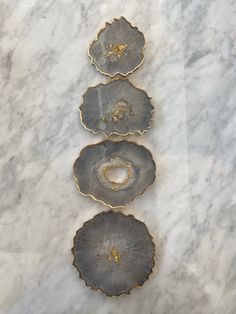 three pieces of metal sitting on top of a marble counter