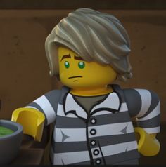 a lego man holding a bowl of green liquid