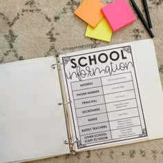 a binder with notes and pens on it sitting next to a pair of scissors