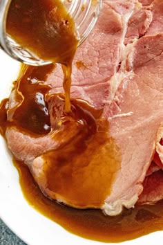 the ham is being drizzled with gravy