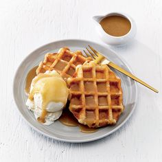 two waffles on a plate with ice cream and syrup