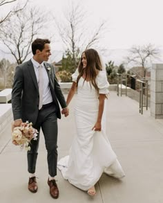 a newly married couple walking down the sidewalk