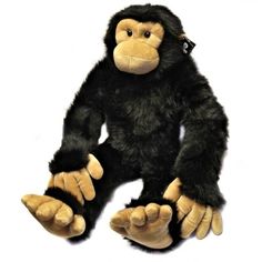 a stuffed monkey sitting on top of a white surface with its hands up to the side