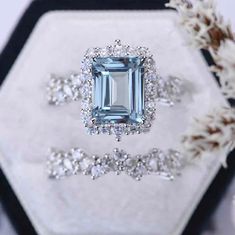 an aqua blue diamond surrounded by white diamonds on top of a black and white hexagonal box