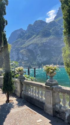 an outdoor area with stone walls and large mountains in the background, along with water