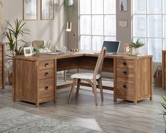 a wooden desk with two chairs and a laptop on it