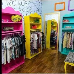 a room filled with lots of different colored shelves and clothes on top of wooden floors